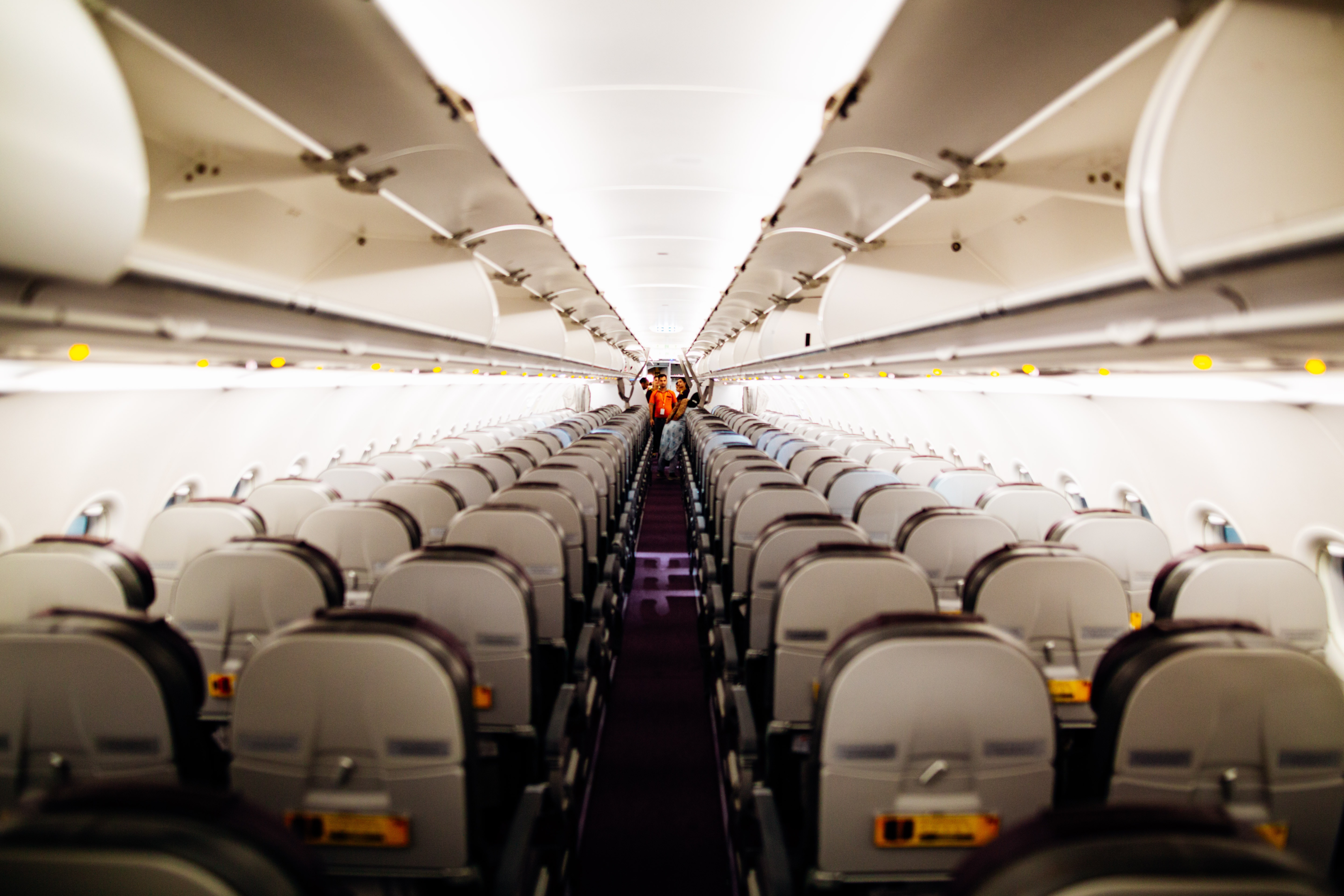 Rows of empty airplane seats on board an aircraft.