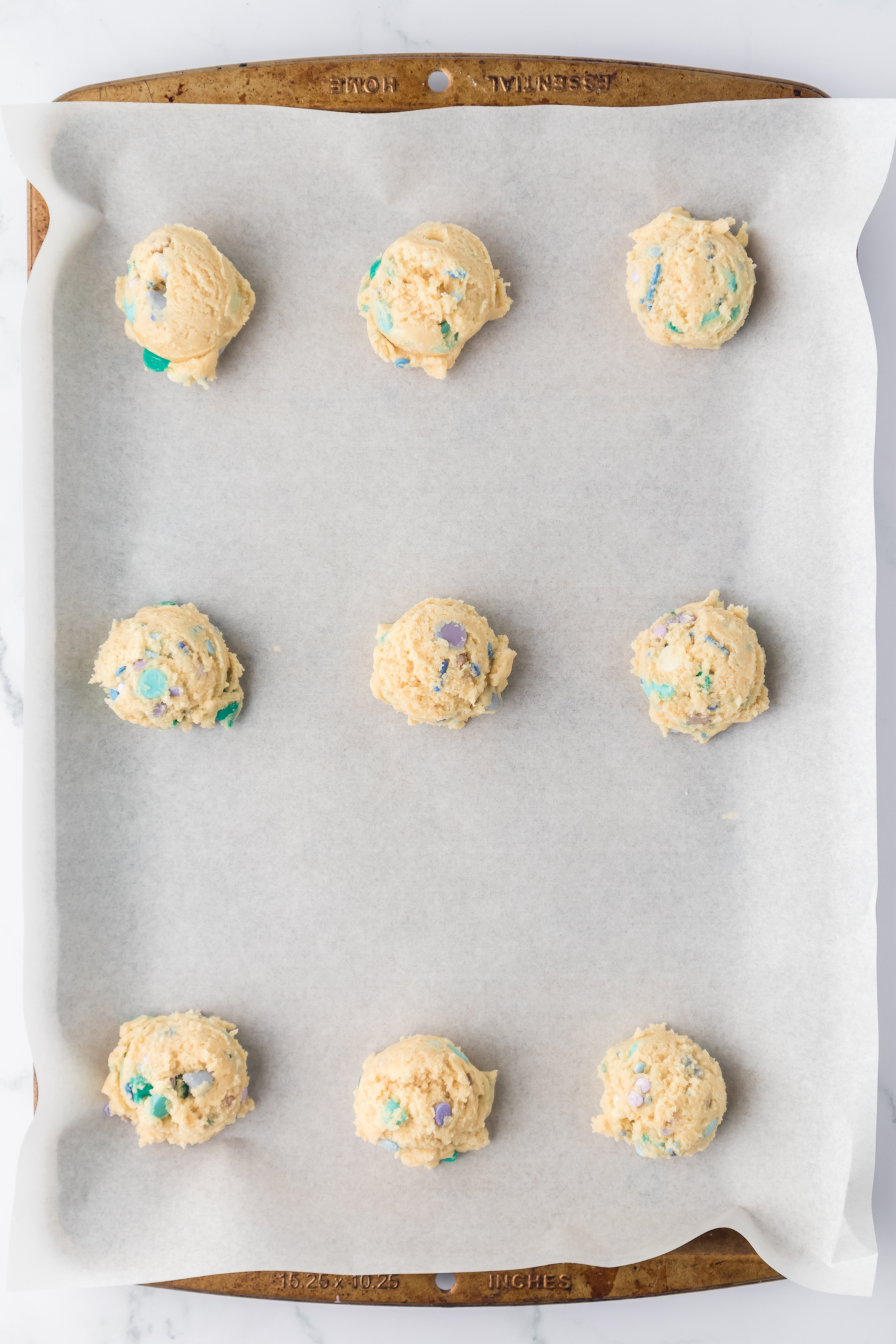 scooped cookie dough on a baking sheet