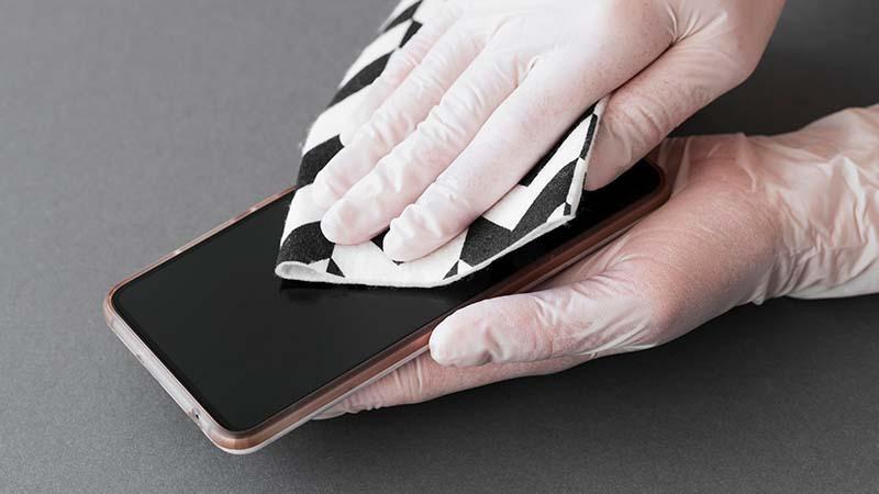 Cleaning the phone screen with a microfiber cloth