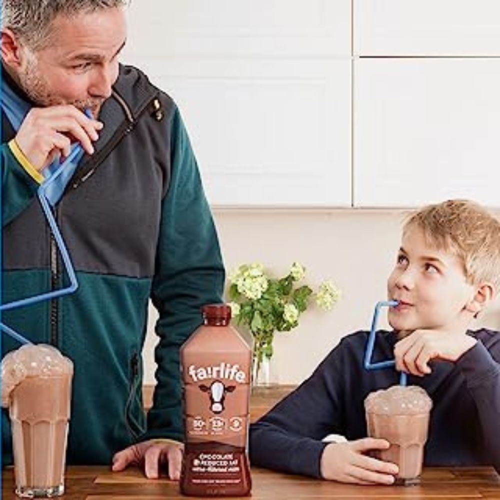 A person holding a bottle of Fairlife protein shake with a satisfied expression