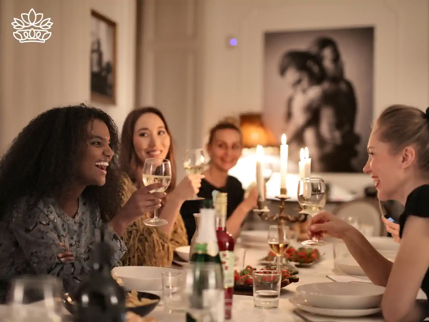 Group of friends having a dinner party with wine glasses raised - Fabulous Flowers and Gifts: Gift Boxes with Champagne and Wine.