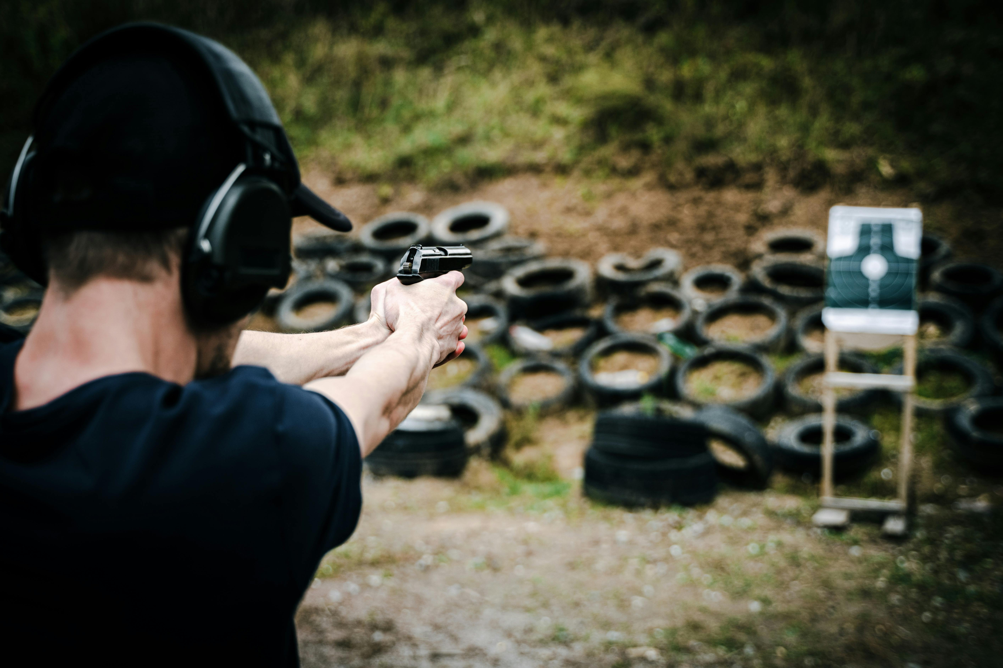 man aiming gun at a target for target shooting practice