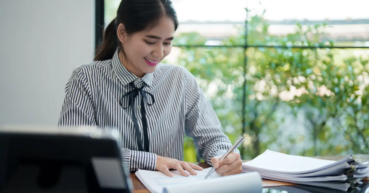 Woman reviewing legal documents for LLC resolution while managing her OnlyFans business finances.