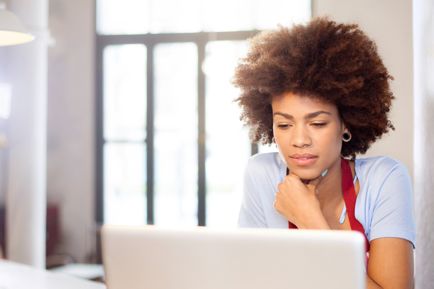 A business owner looking at a laptop with a concerned expression.