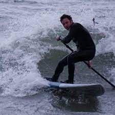 surfing waves a paddle board on lake michigan