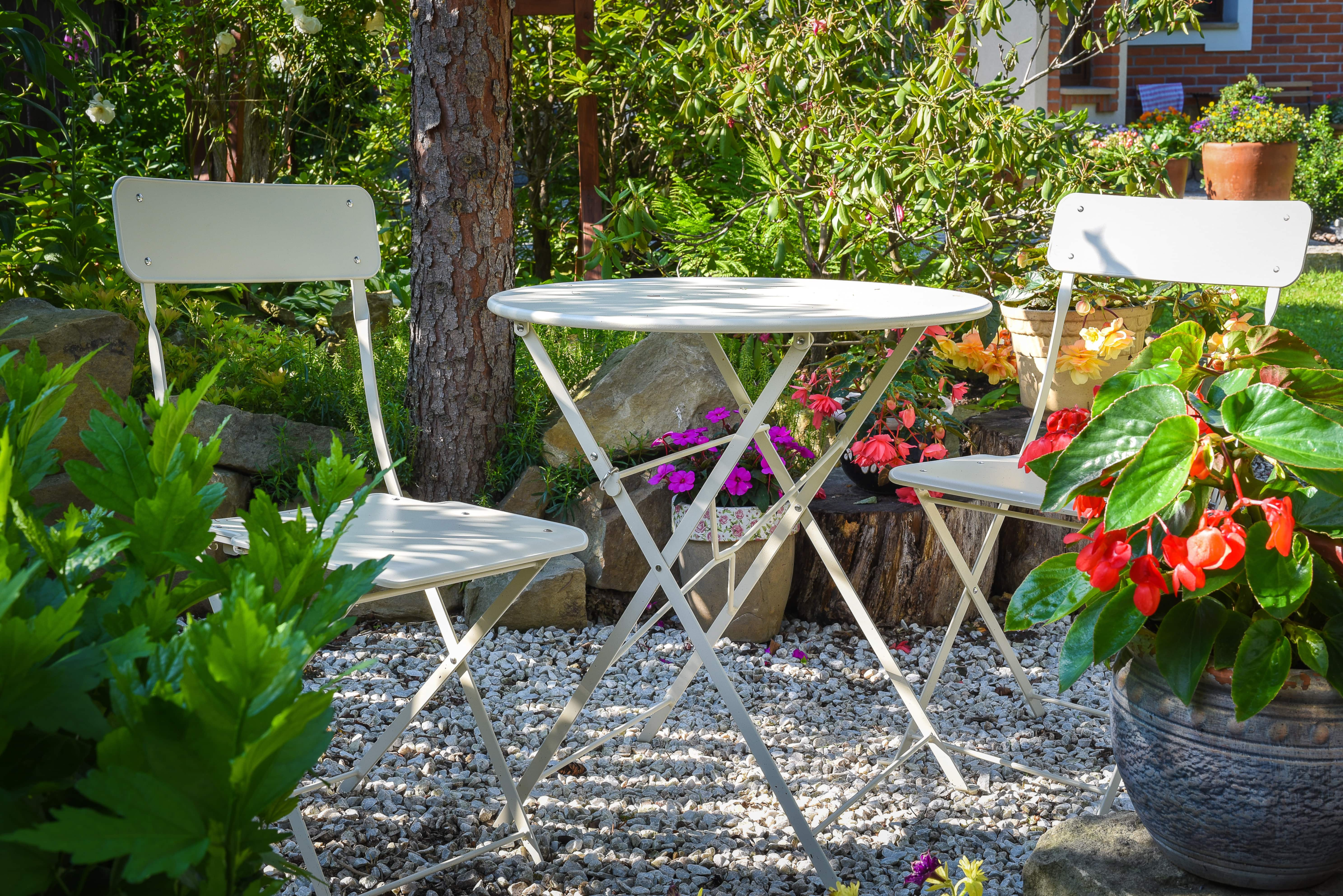 a bistro table amongst a flower garden