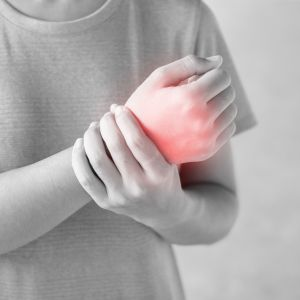 Person holding wrist with carpal tunnel syndrome