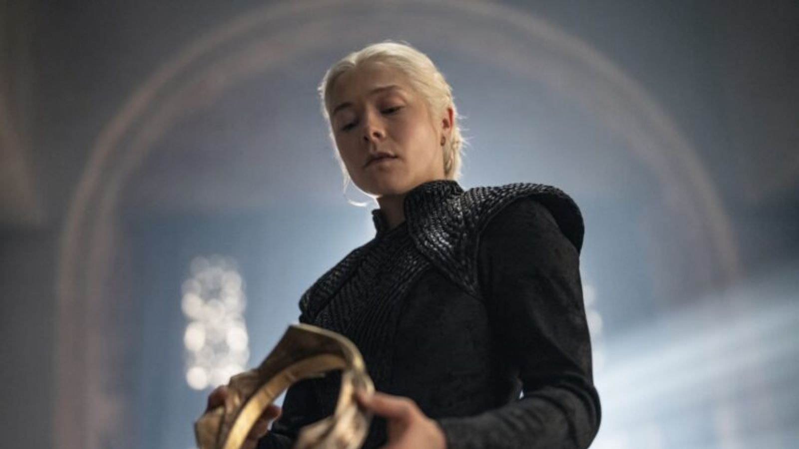 Emma D'Arcy holding the royal crown in dimly lit throne room in House of the Dragon Season 3
