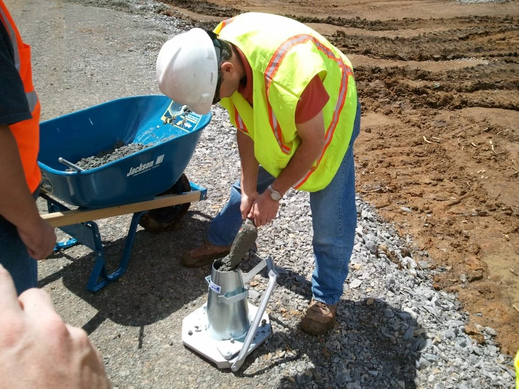A technician performing a basic field test on freshly mixed concrete