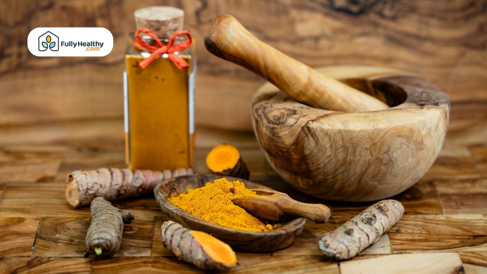 Turmeric powder, fresh roots, bottle and wooden mortar on table