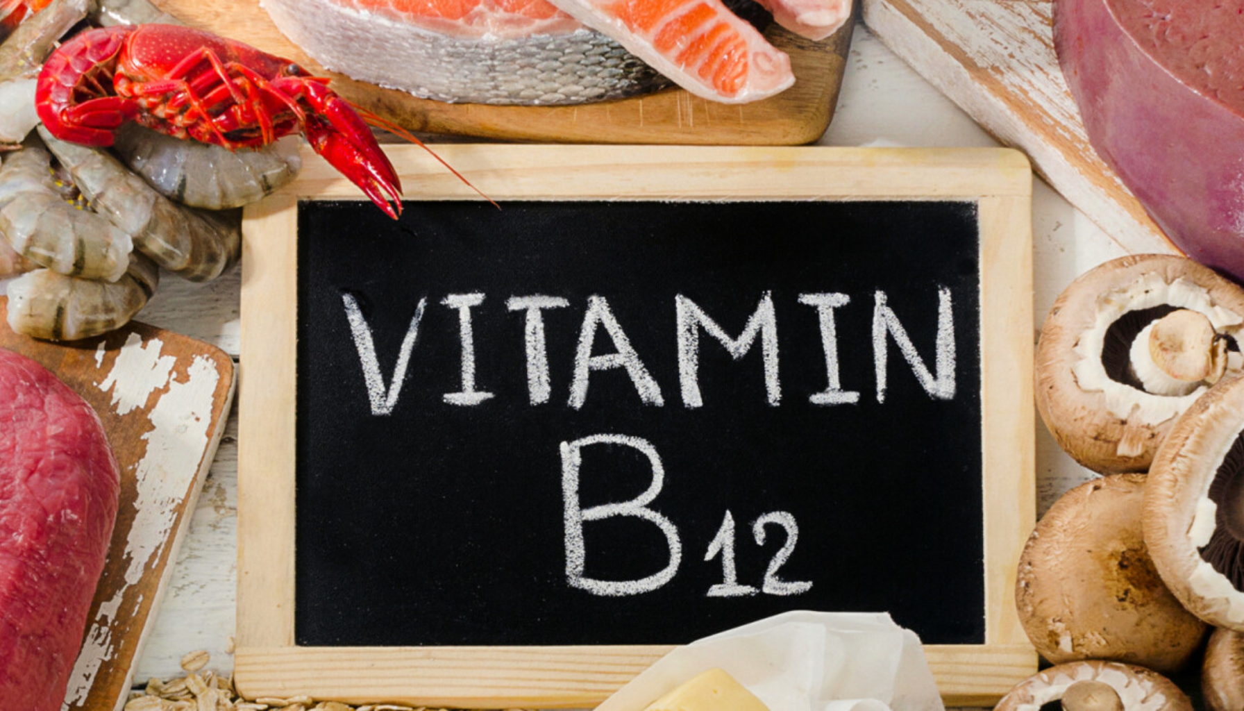 B12-mangel – Symptomer du ikke bør ignorere 9 Matvarer rike på vitamin B12 som kjøtt, fisk, reker, ost og sopp rundt en tavle med teksten “Vitamin B12”.