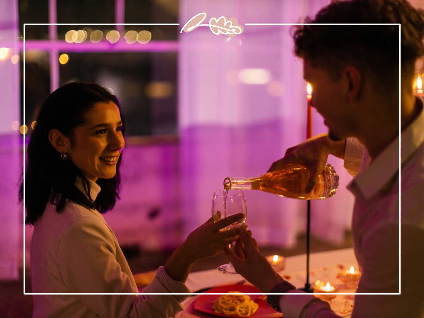 A couple enjoying a romantic dinner with the man pouring champagne for the woman, set in a warmly lit ambiance - Fabulous Flowers and Gifts.