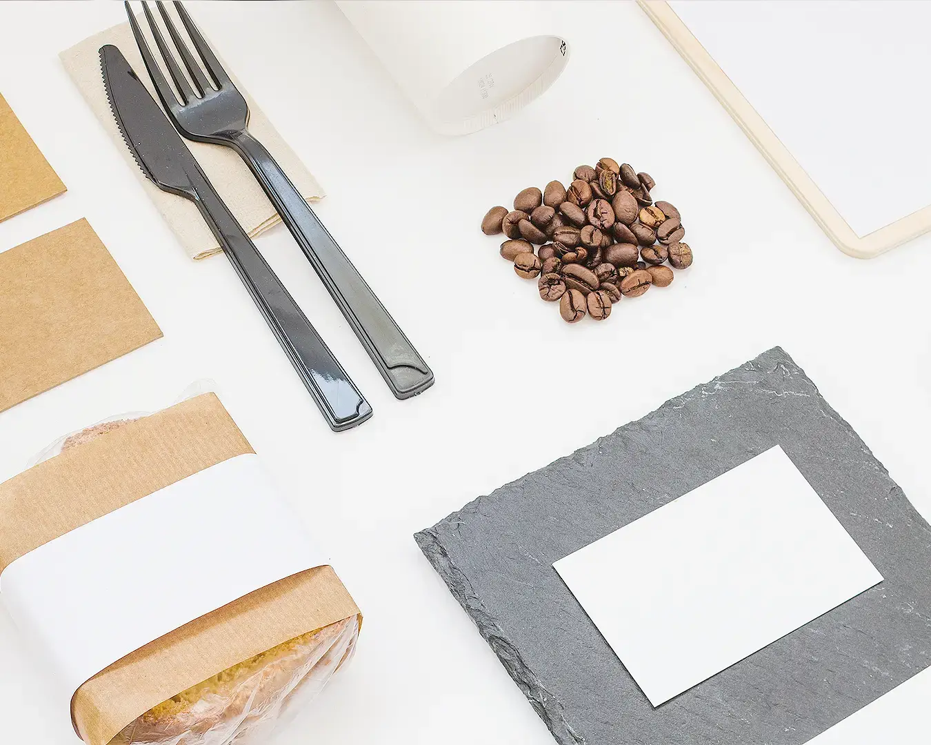 Minimal restaurant branding flat lay with coffee beans, cutlery, packaging, and menu design elements