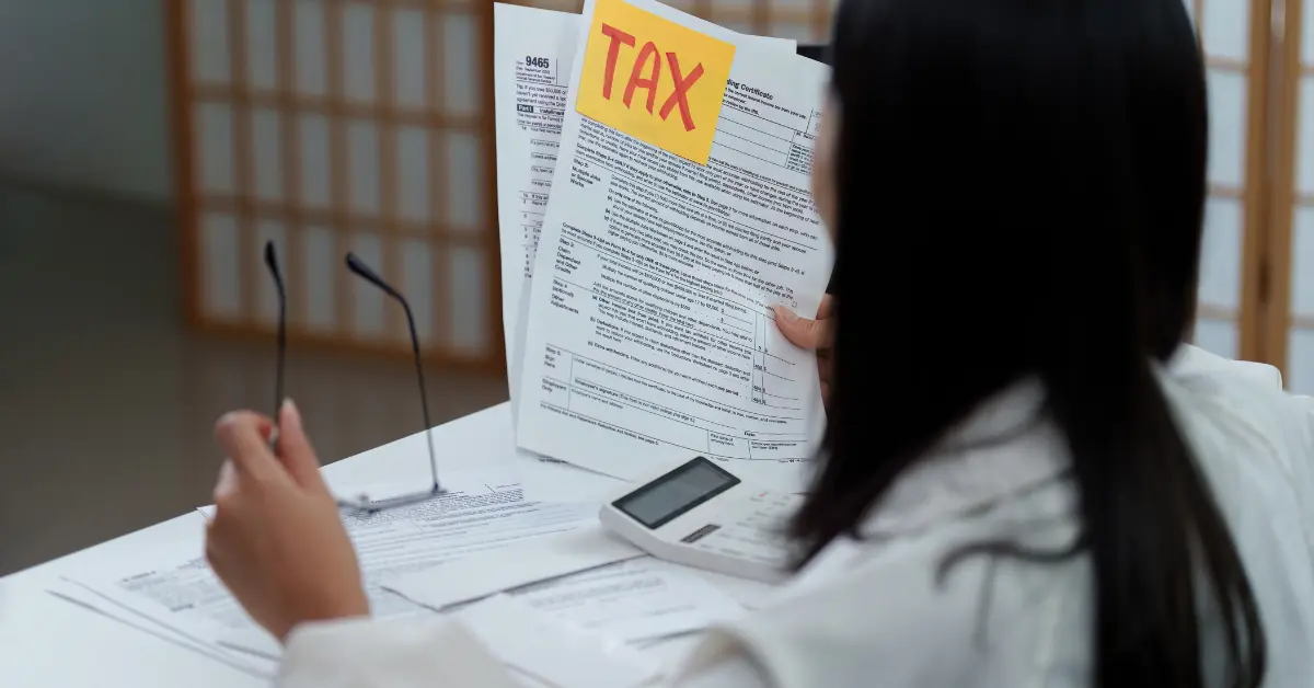 Woman organizing tax documents and planning a late s corp election for OnlyFans taxes and business compliance.