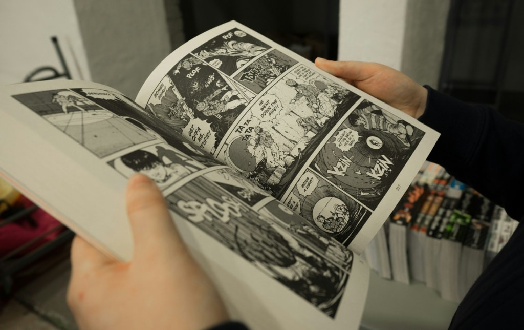 A person holding open a physical manga book