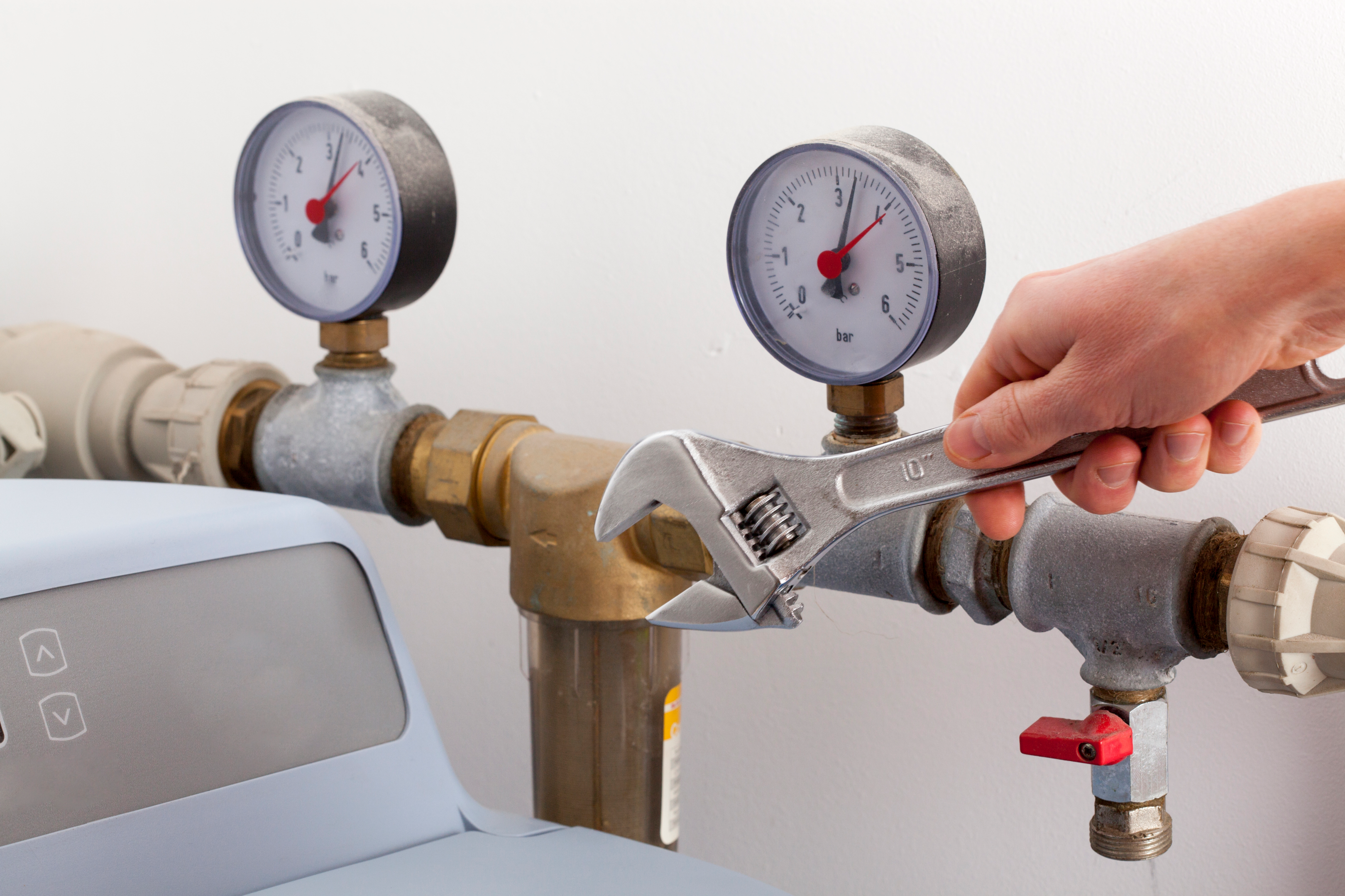 A person installing a bypass valve for a water softener system