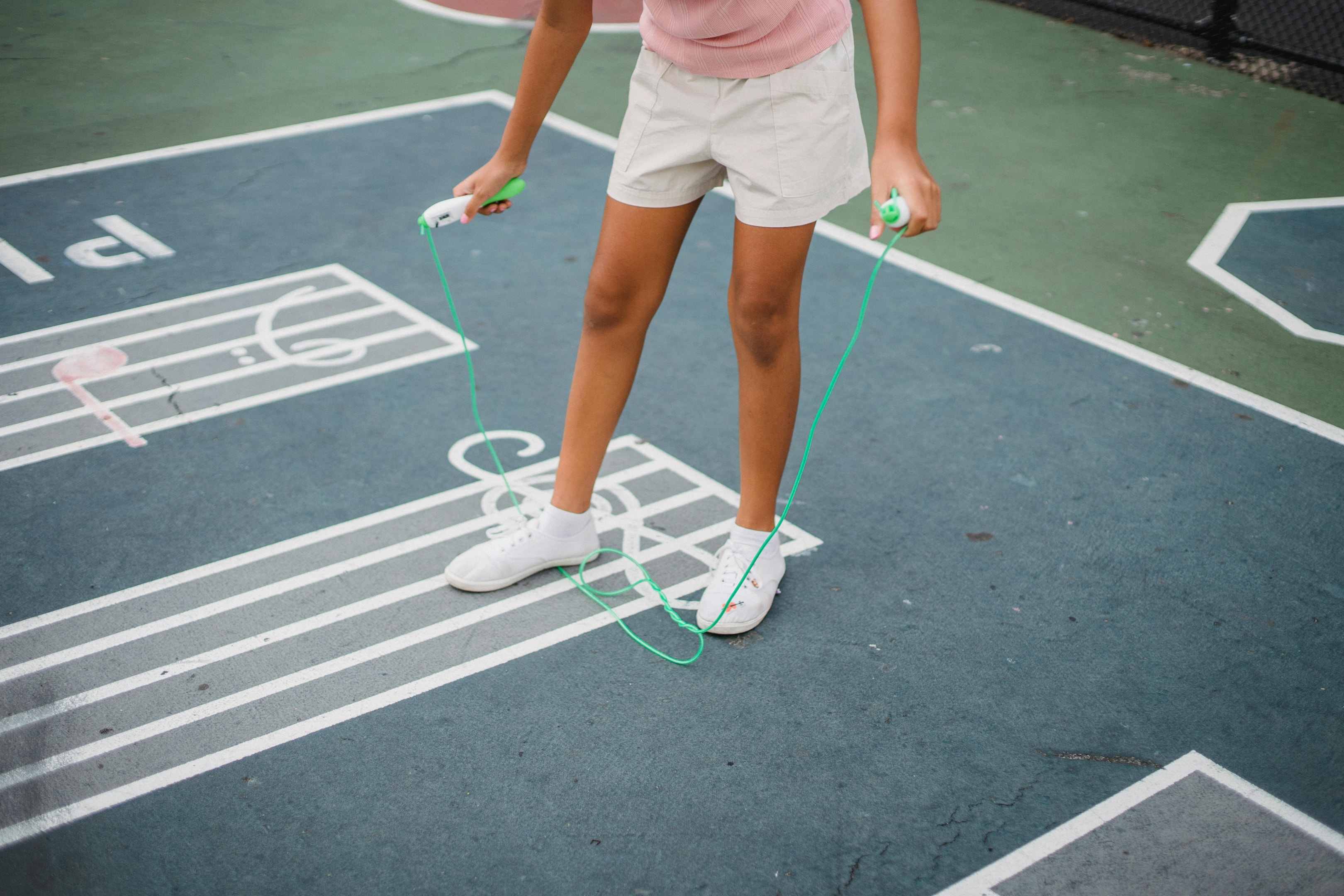 Photo by Antonius Ferret: https://www.pexels.com/photo/woman-in-pink-tank-top-and-white-shorts-stepping-on-a-jump-rope-5275787/