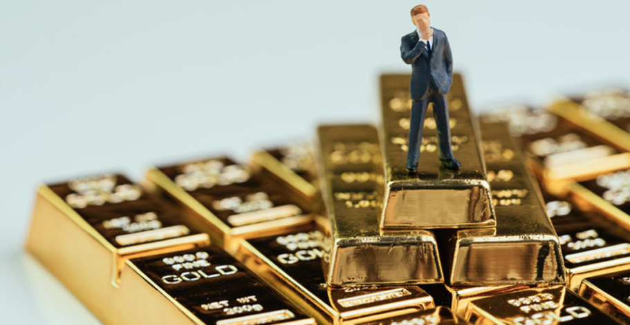 A person standing on top of stack of gold bars