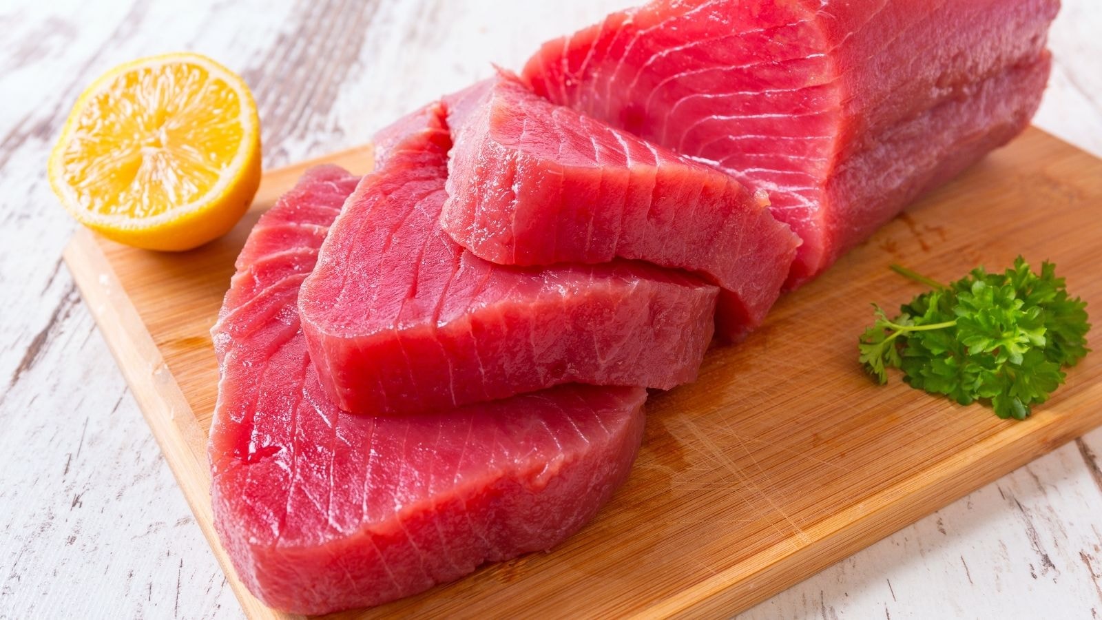Sliced fresh tuna steaks with lemon and parsley