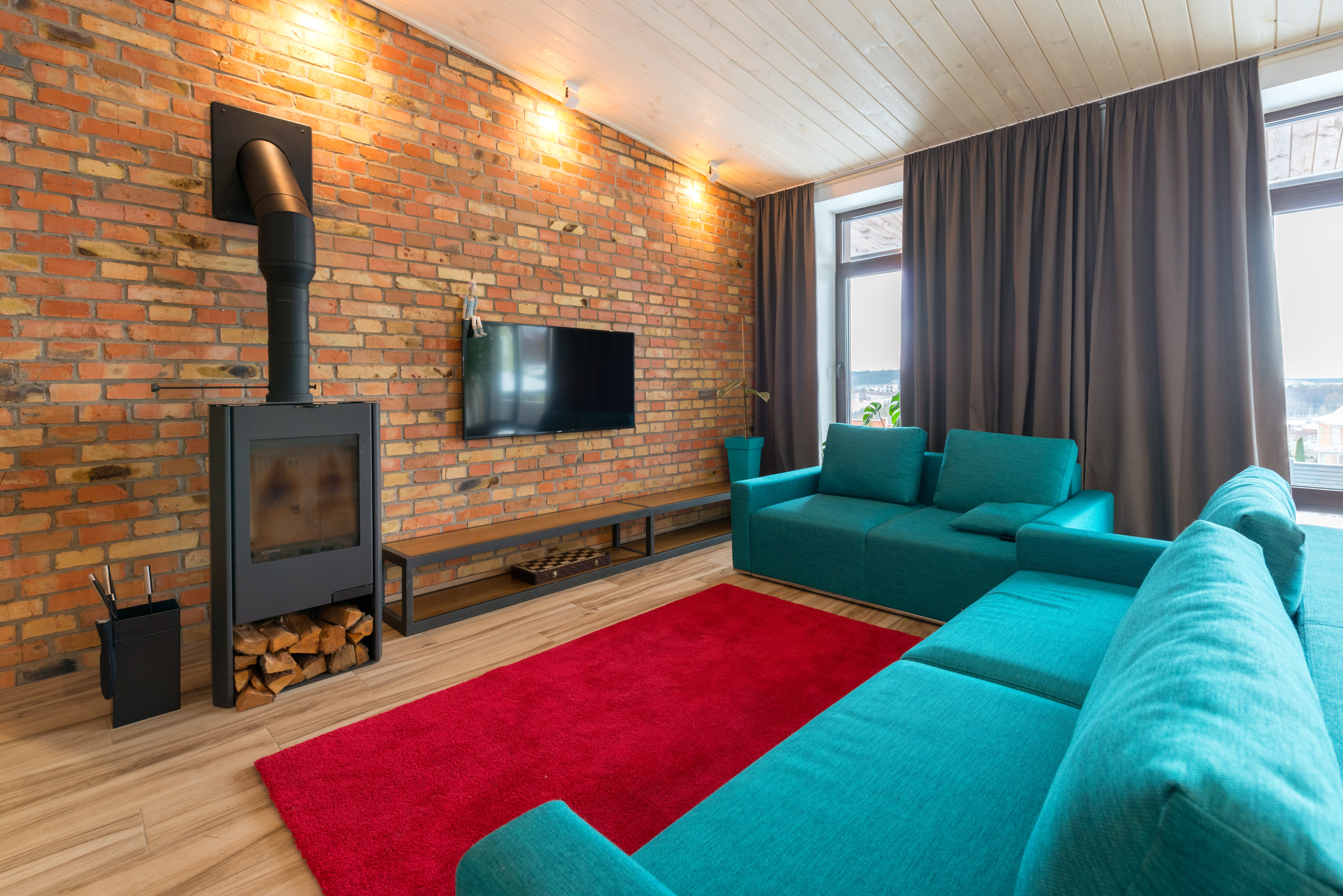 teal sofa red rug brick wall