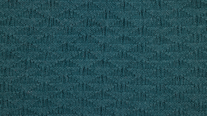 A close up of a teal colored textured fabric