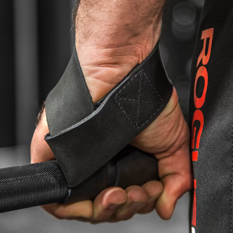 A person using lifting straps to improve their grip while lifting heavy weights