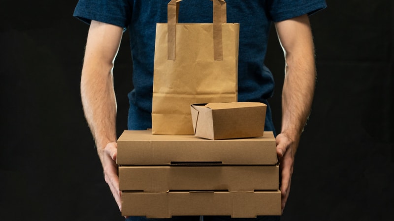 A man holding takeaway boxes