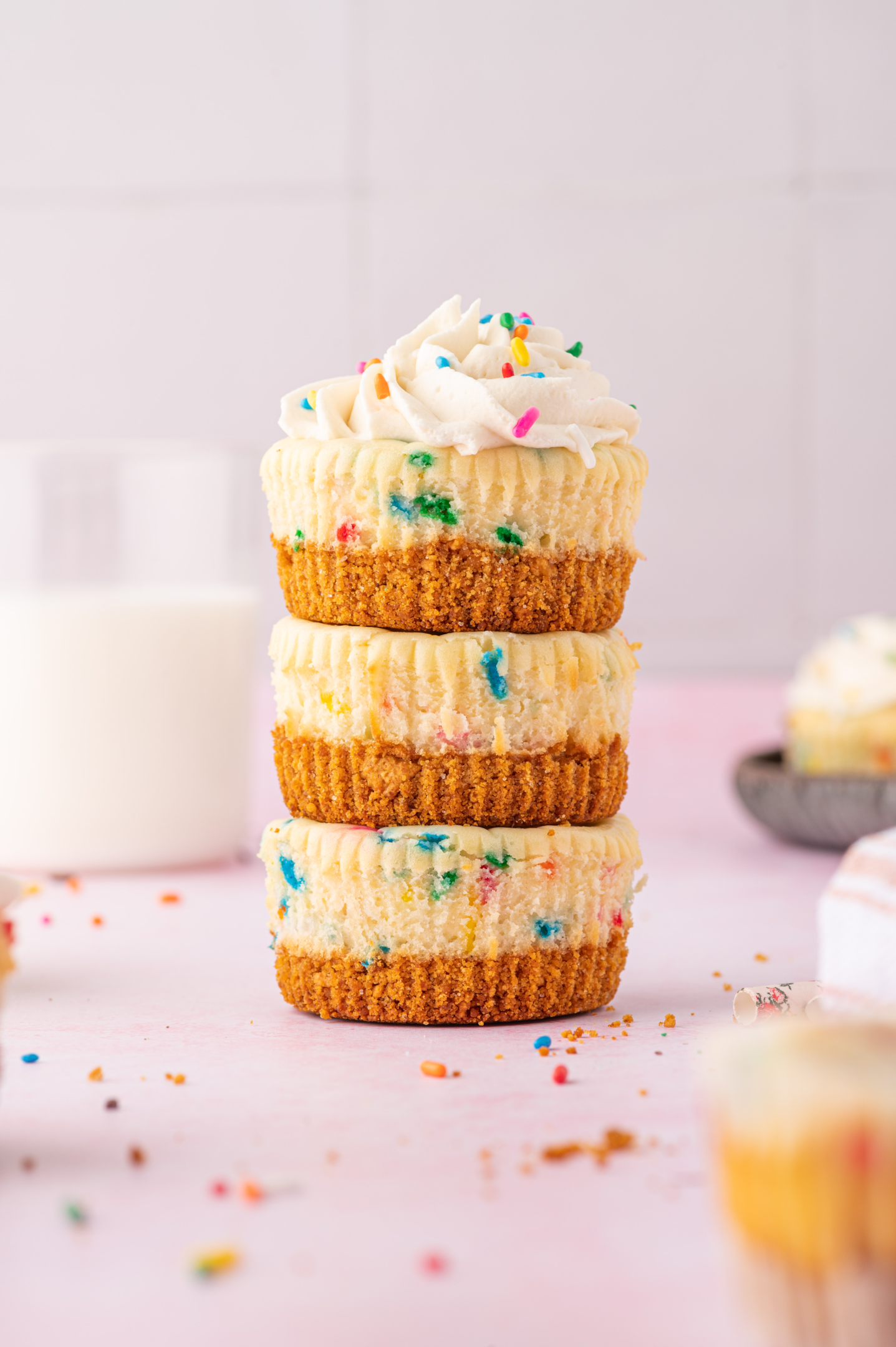 three mini funfetti cheesecakes stacked on top of each other without paper liners