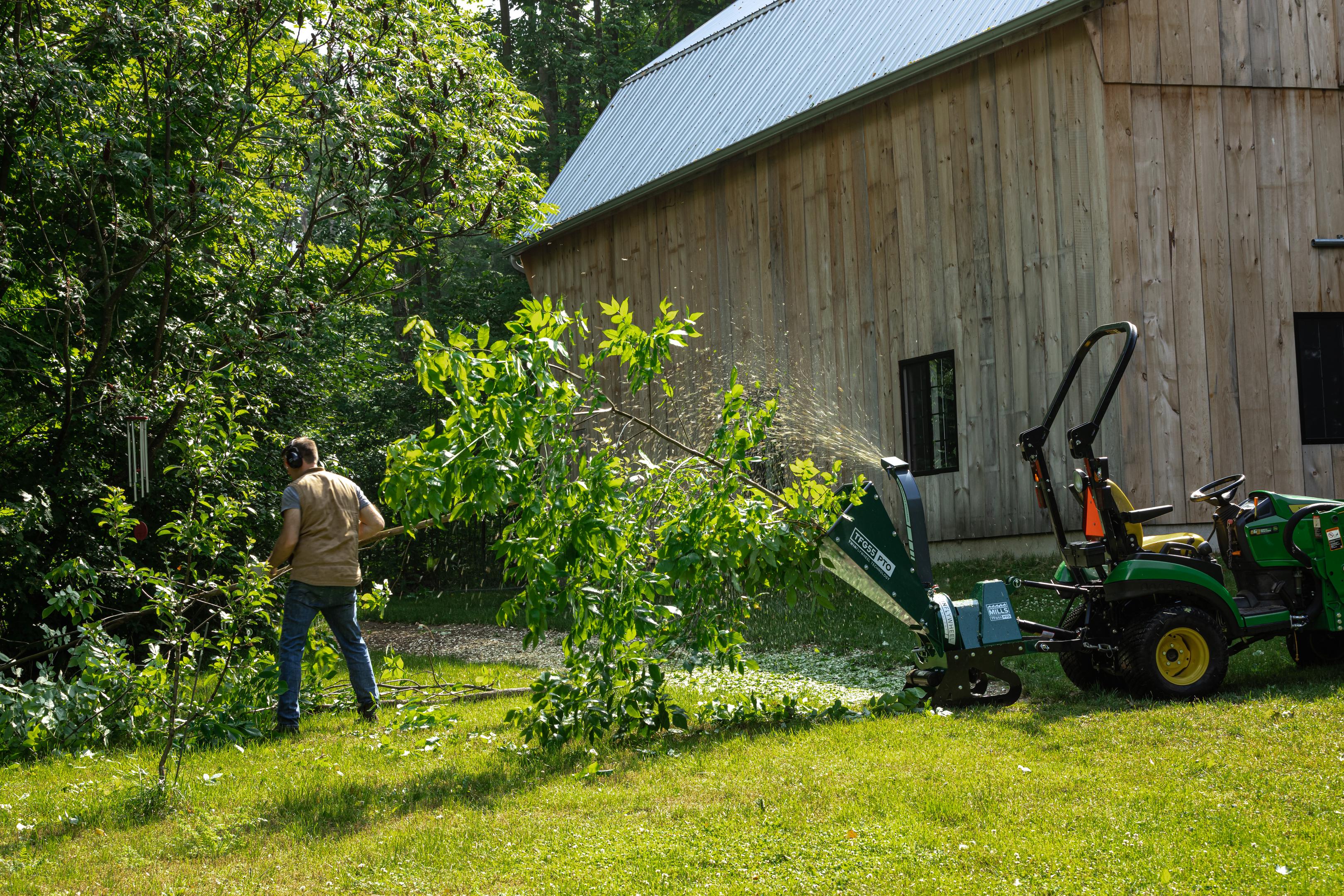 A tree being fed into a Woodland Mills TFG55 GAS Wood Chipper.