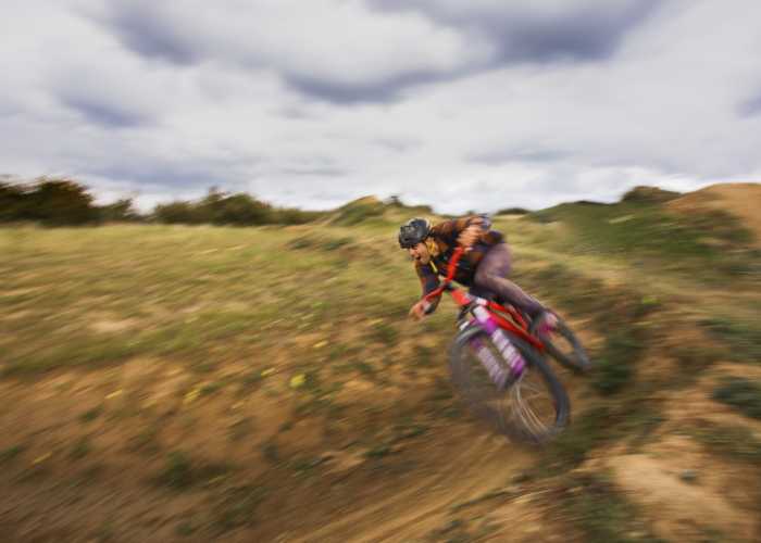 A mountain biker riding a mountain bike on a flat surface