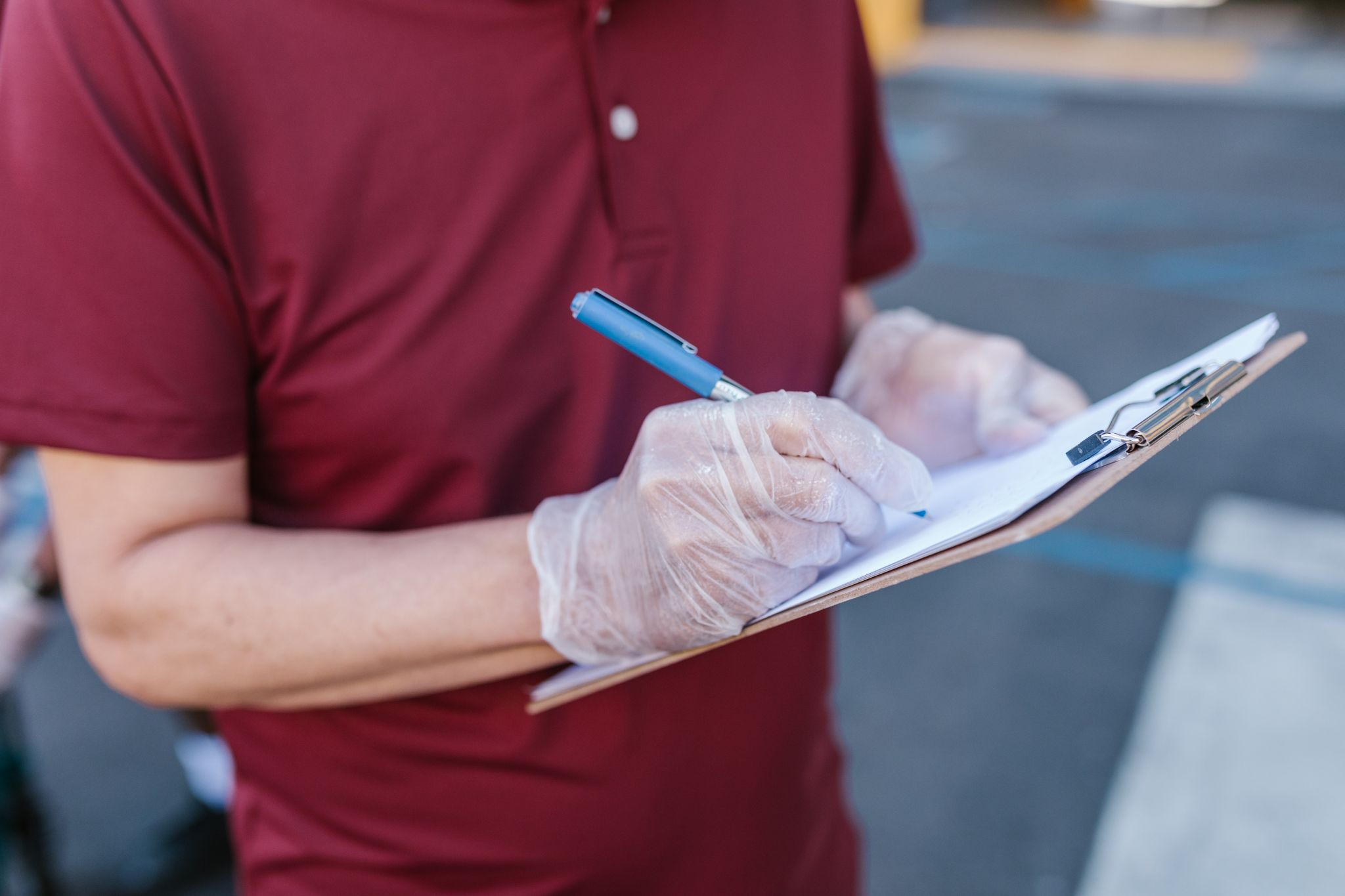 A close-up of a person writing on a clipboard