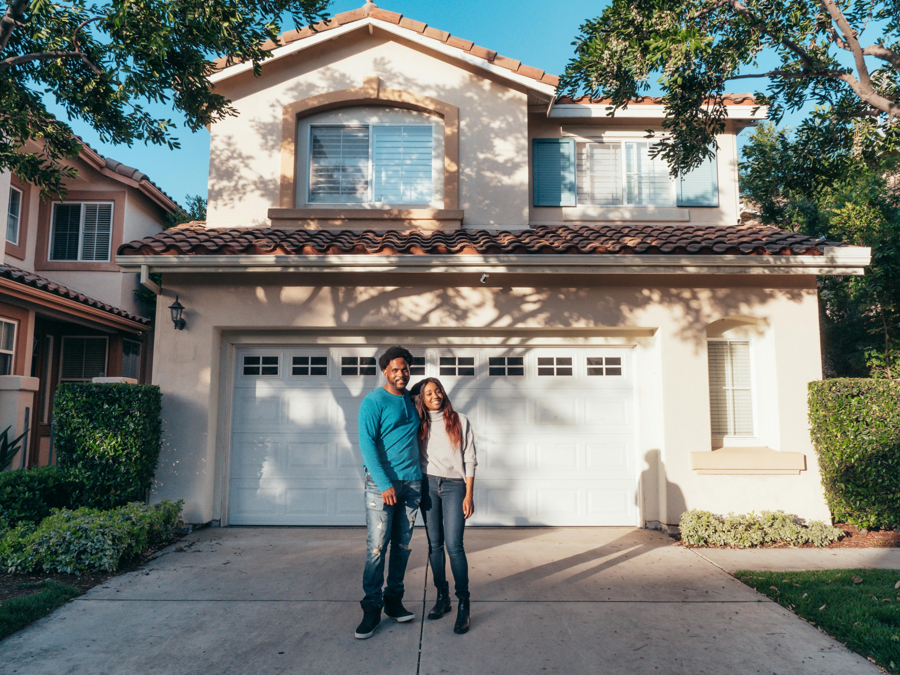 Homeowners standing in front of their home.