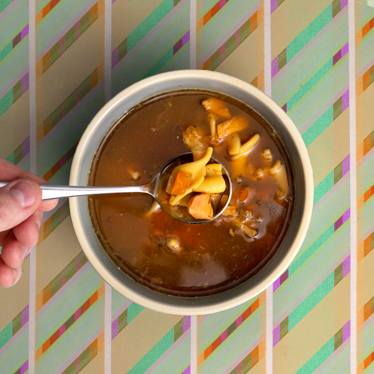 A bowl of low carb soup with sides and toppings