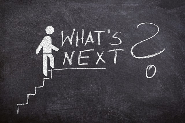 A chalkboard with an image of a person walking up stairs, with the phrase 'What's Next?' representing the idea of taking the next step in your writing career.