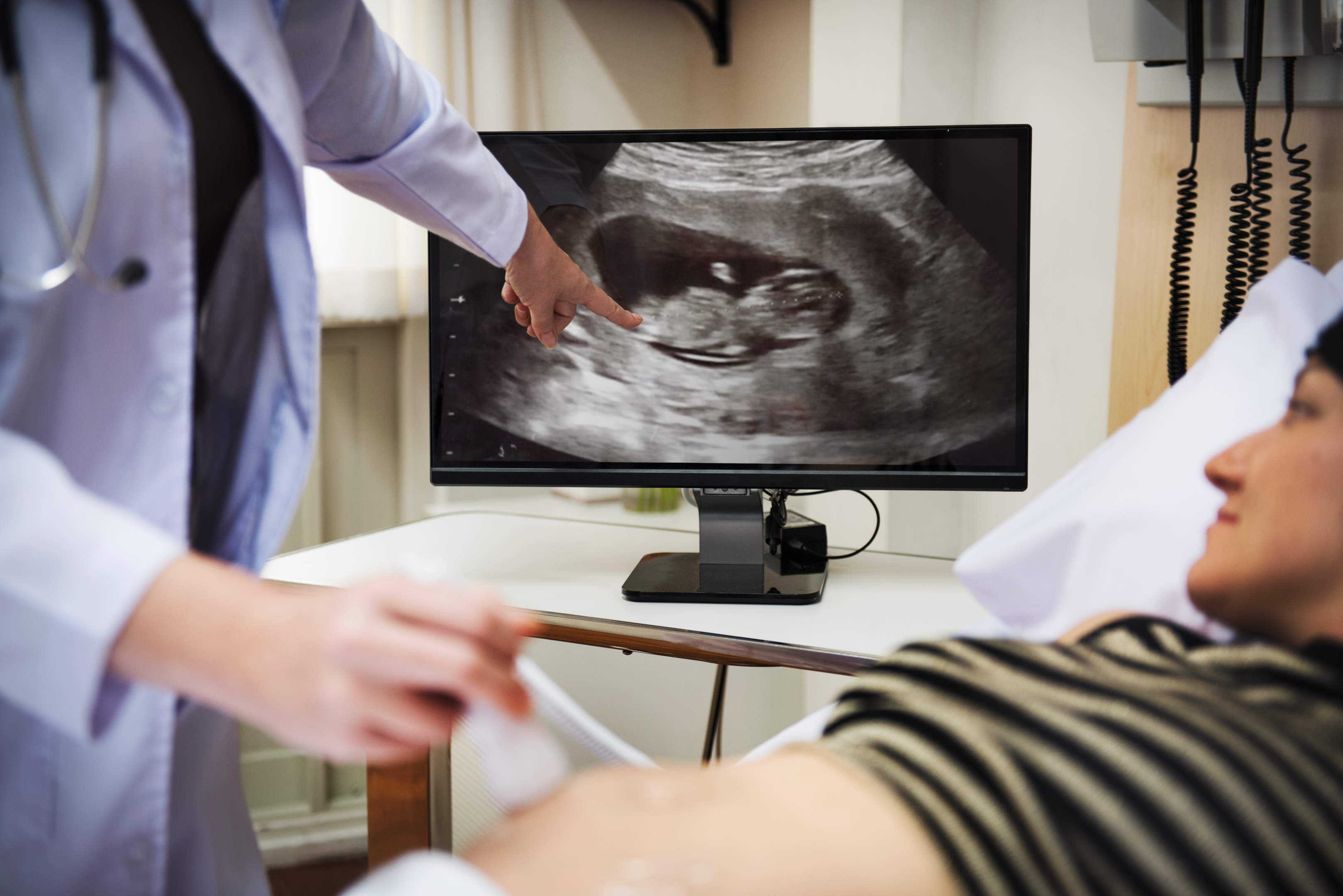 doctor showing ultrasound of baby reviewing baby healthy behavior in belly