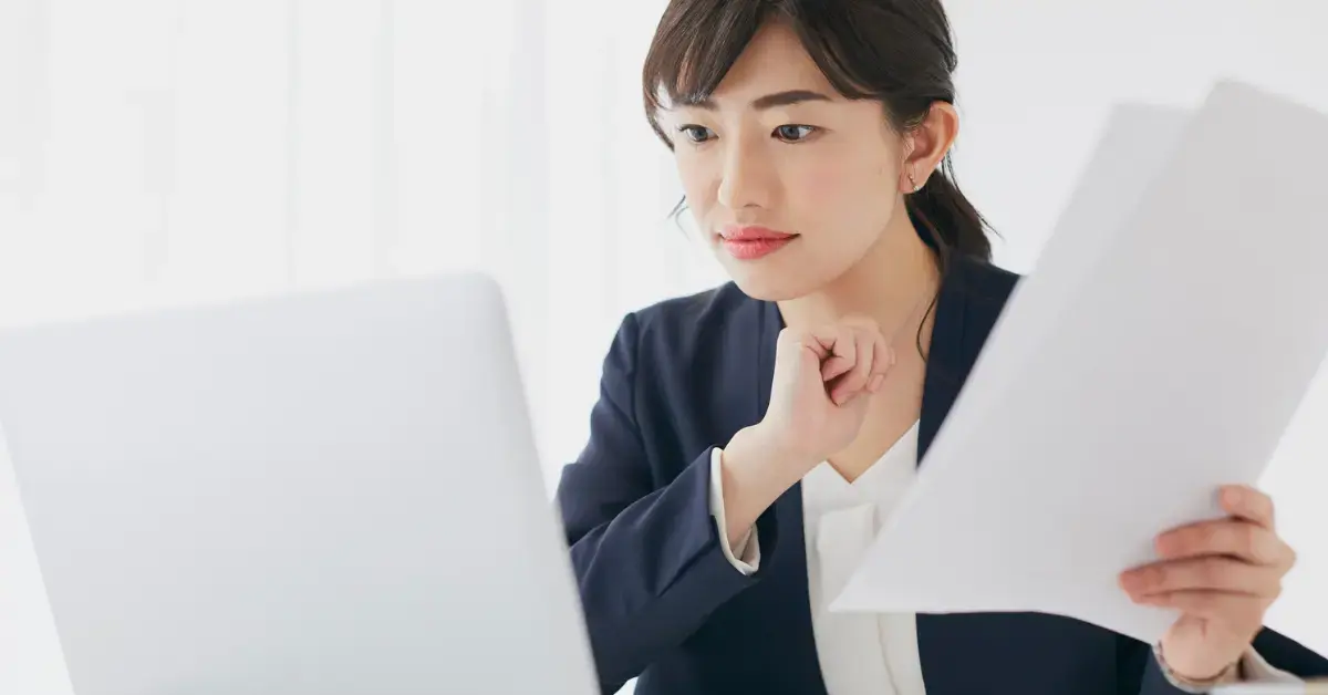 Woman preparing a past-due tax return to correct a substitute for return IRS assessment.