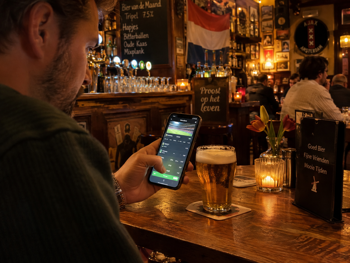 Sportweddenschappen plaatsen op een smartphone in een Nederlandse kroeg tijdens een voetbalwedstrijd.