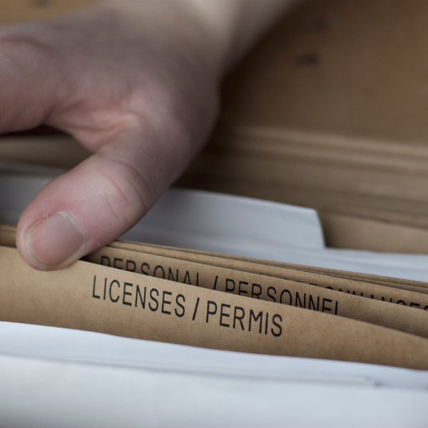 An image showing a person reviewing painter's licenses and insurance documents.