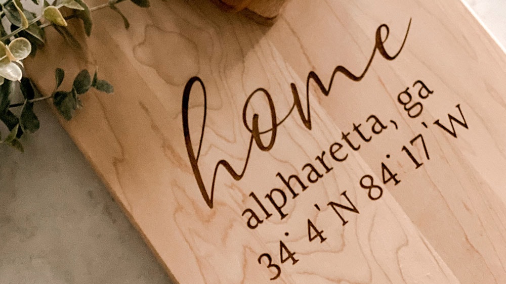 personalized cutting board with the words home, alpharetta, ga and geo coordinates by HomeBound Designs