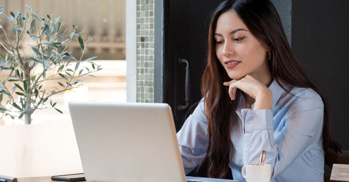 Female content creator reviewing non-deductible expenses for OnlyFans taxes while working on a laptop.