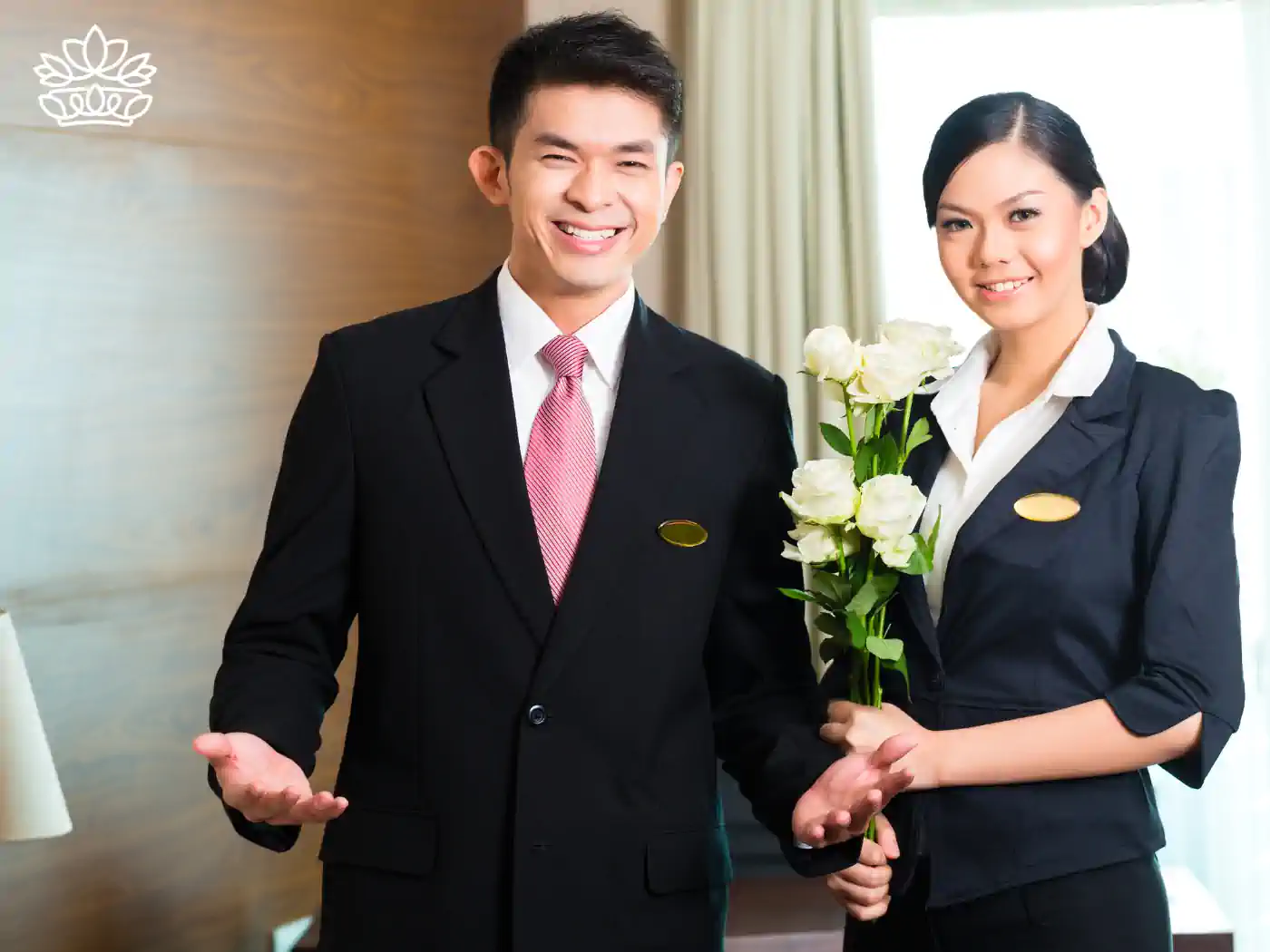 Professional hotel staff presenting elegant white roses, symbolizing exceptional guest service. Fabulous Flowers and Gifts, Guest House and Hotel Gift Boxes Delivered with Heart.