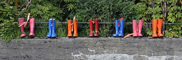 a line of pink, blue, orange and red rain boots for kids