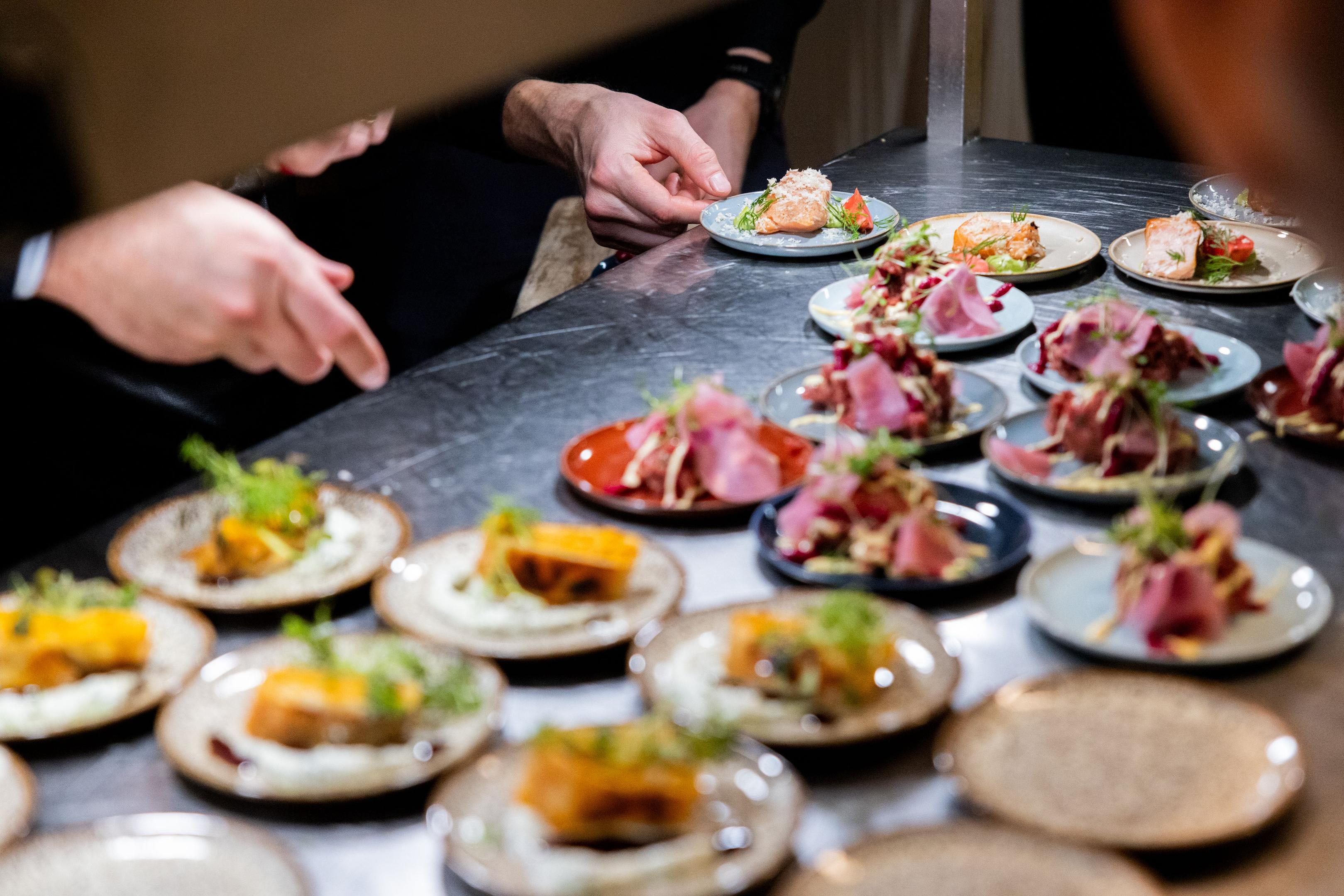 A bustling restaurant kitchen where chefs plate vibrant, colorful dishes during a busy dinner service.