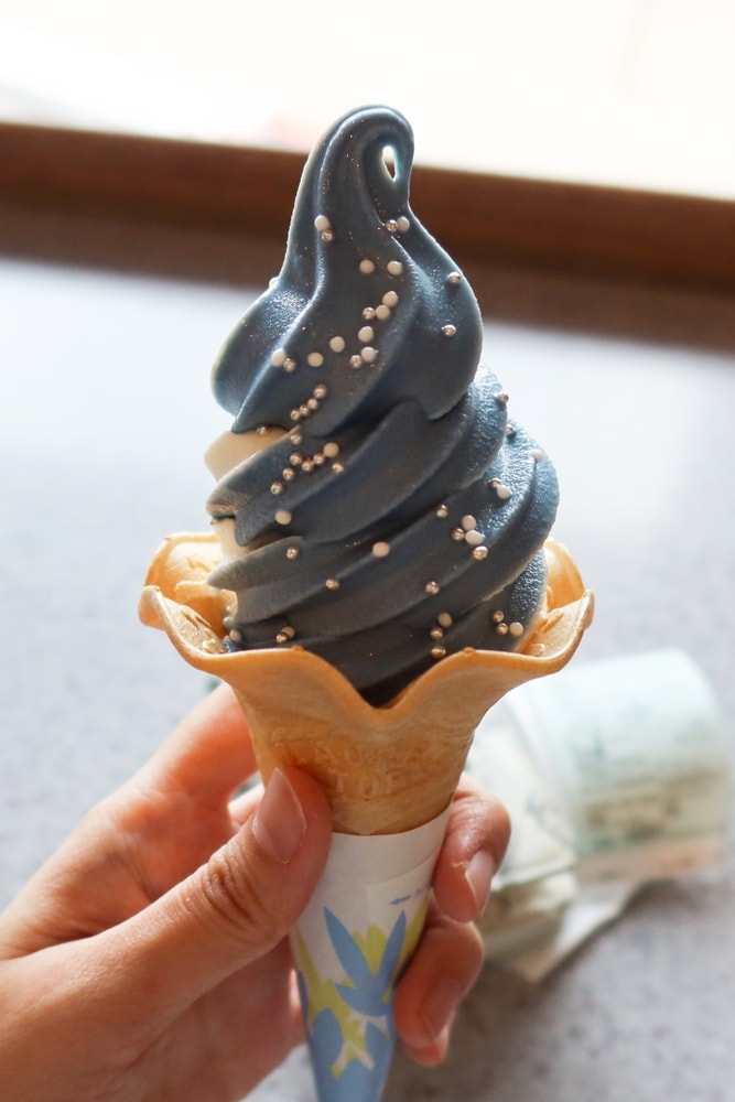 Osaka, Japan – April 15, 2024 Hand holding a Whale Shark Soft Serve (Jinbei Soft), a Ramune and vanilla-flavored ice cream, a novelty ice cream treat found at the Osaka Aquarium Kaiyukan in Japan.