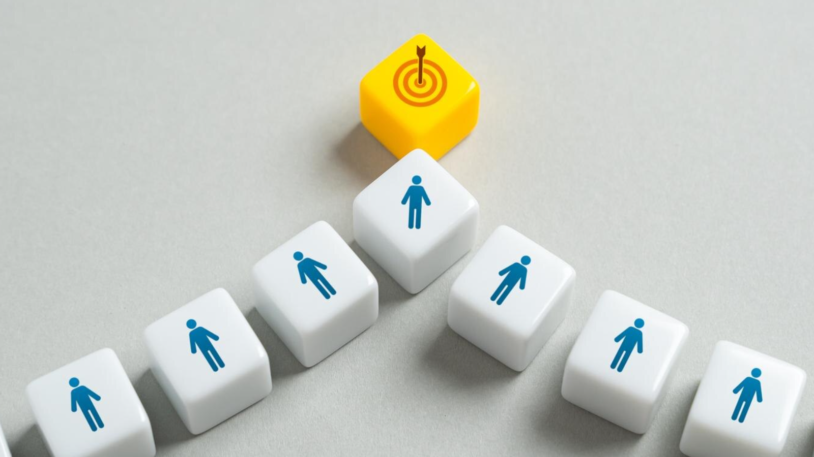 Cubes with human icons leading to a target, symbolizing mapping content to the buyer's journey to reach potential customers.
