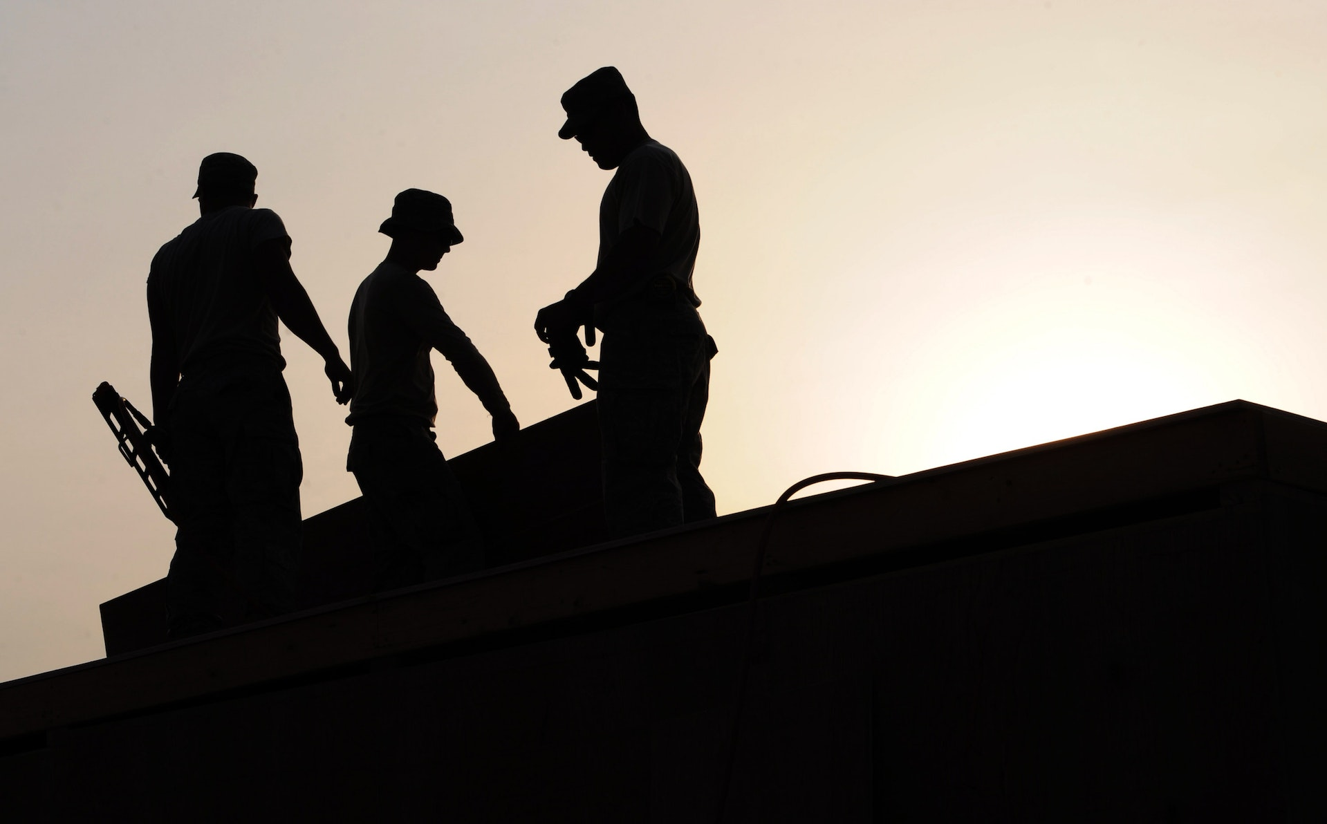 Construction workers in hard hats and safety vests working on a building