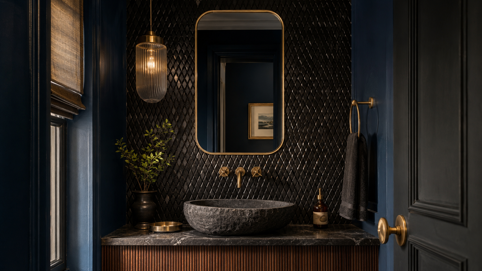 Black Cavastone rhombus mosaic accent wall in a luxury powder room with sapphire walls and brass finishes.