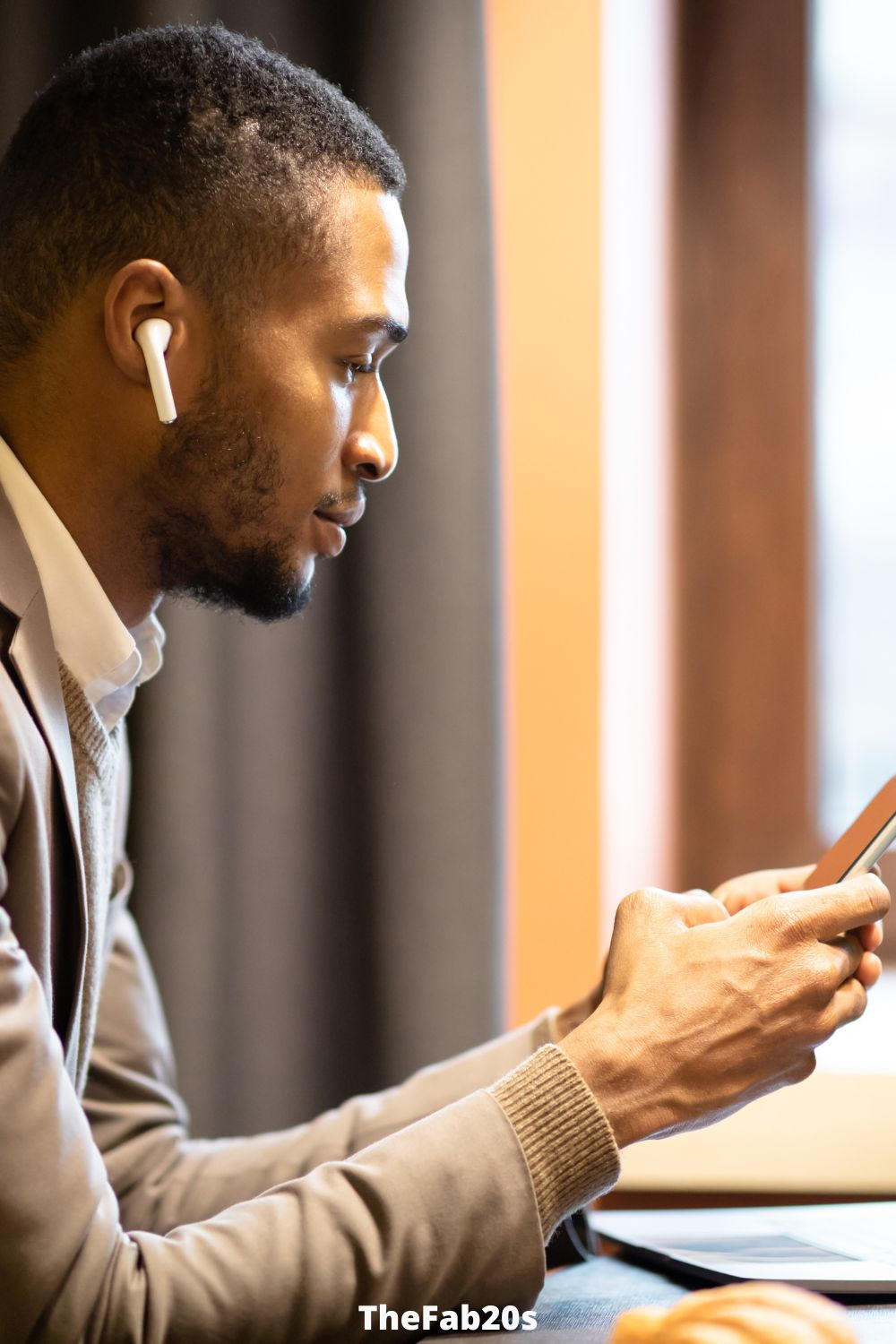 Man checking phone with airpods in his ear