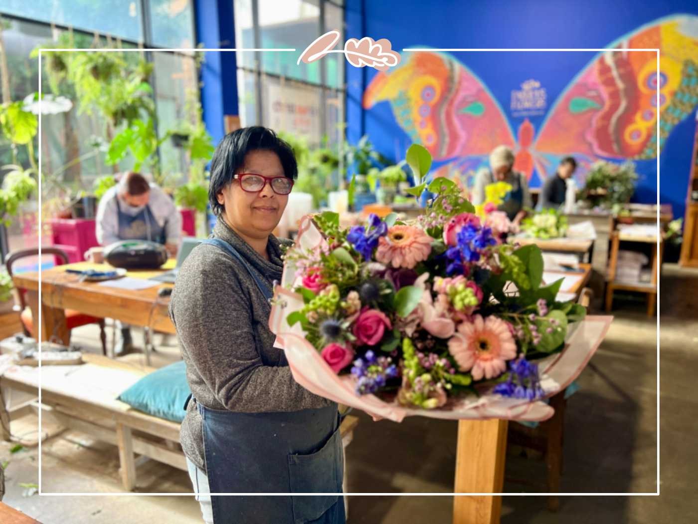 Florist holding a colorful bouquet in a vibrant workspace by Fabulous Flowers and Gifts