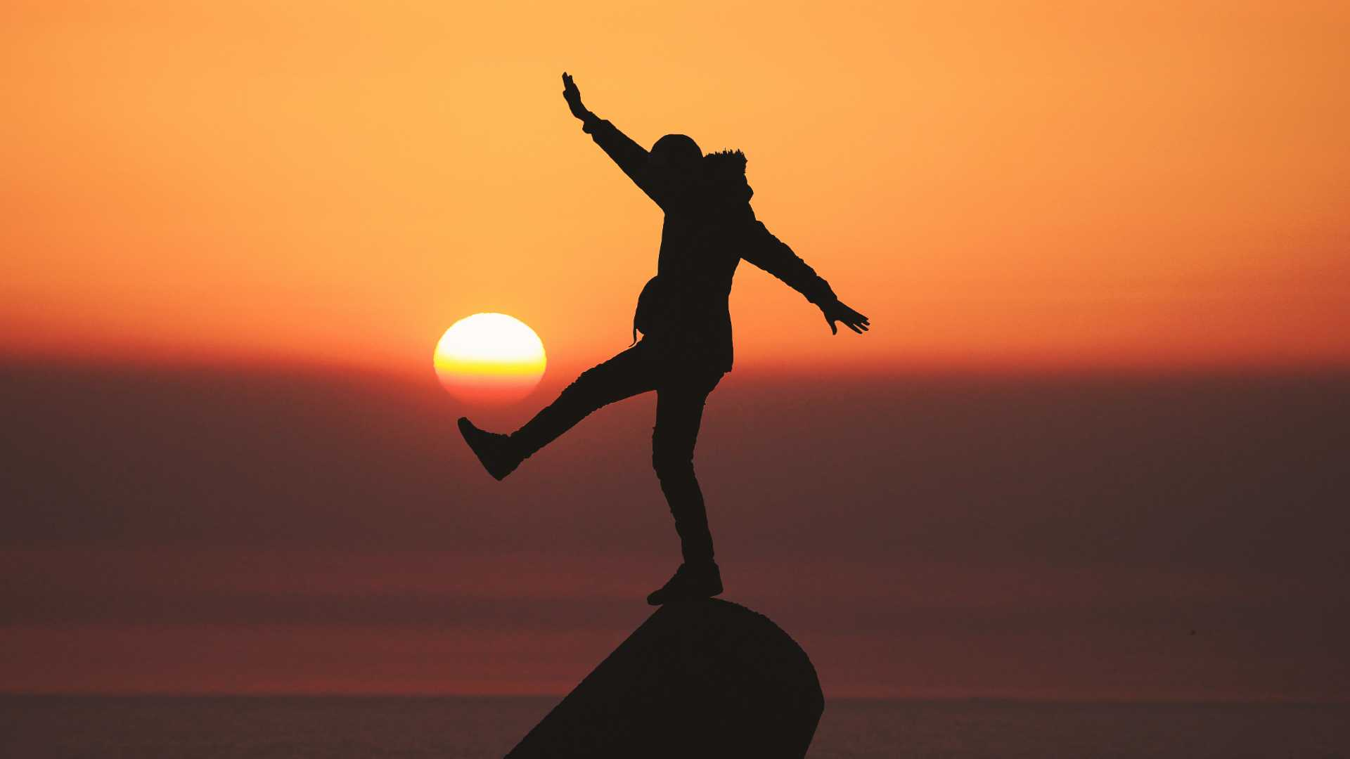 person balances on a rock - finding balance is important in your exercise routine